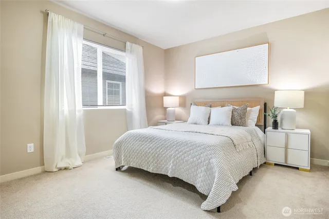 a large bed sitting in a bedroom next to a lamp next to a lamp