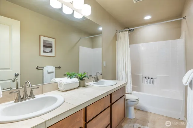 a bathroom with a granite countertop sink mirror toilet and bathtub