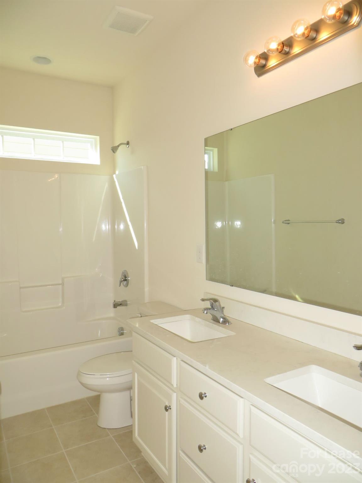5107 Waterloo Drive Tega Cay, SC 29708 - Photo 20 of 25 a bathroom with a double vanity sink toilet and shower