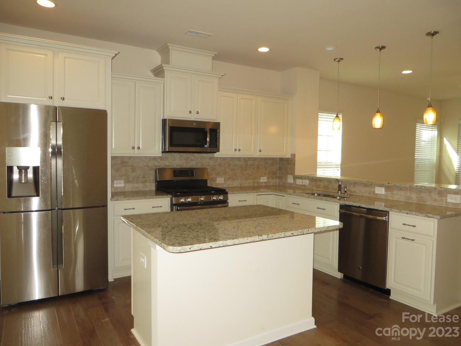 5107 Waterloo Drive Tega Cay, SC 29708 - Photo 2 of 25 a kitchen with a sink a refrigerator a microwave a stove and cabinets