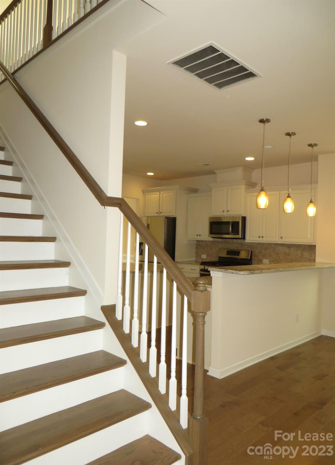 5107 Waterloo Drive Tega Cay, SC 29708 - Photo 24 of 25 a view of kitchen with stainless steel appliances hallway with wooden floor