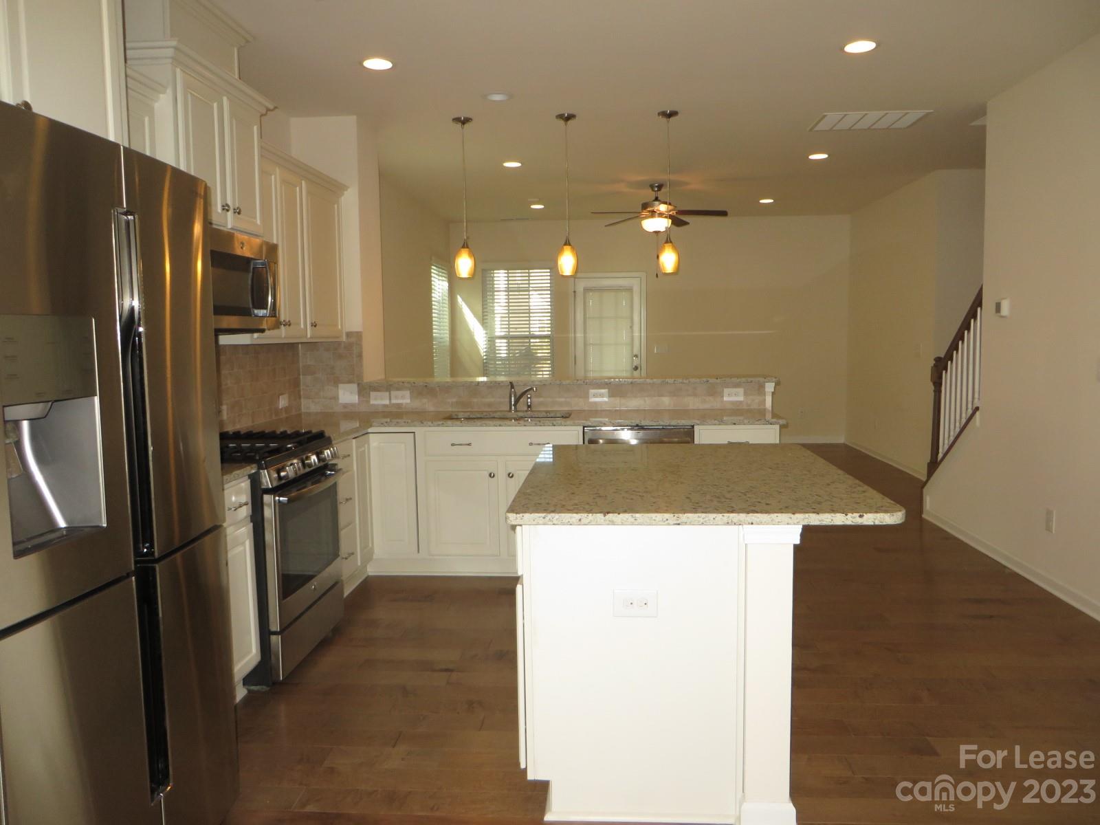 5107 Waterloo Drive Tega Cay, SC 29708 - Photo 3 of 25 a kitchen with a sink a refrigerator and a stove top oven with wooden floor
