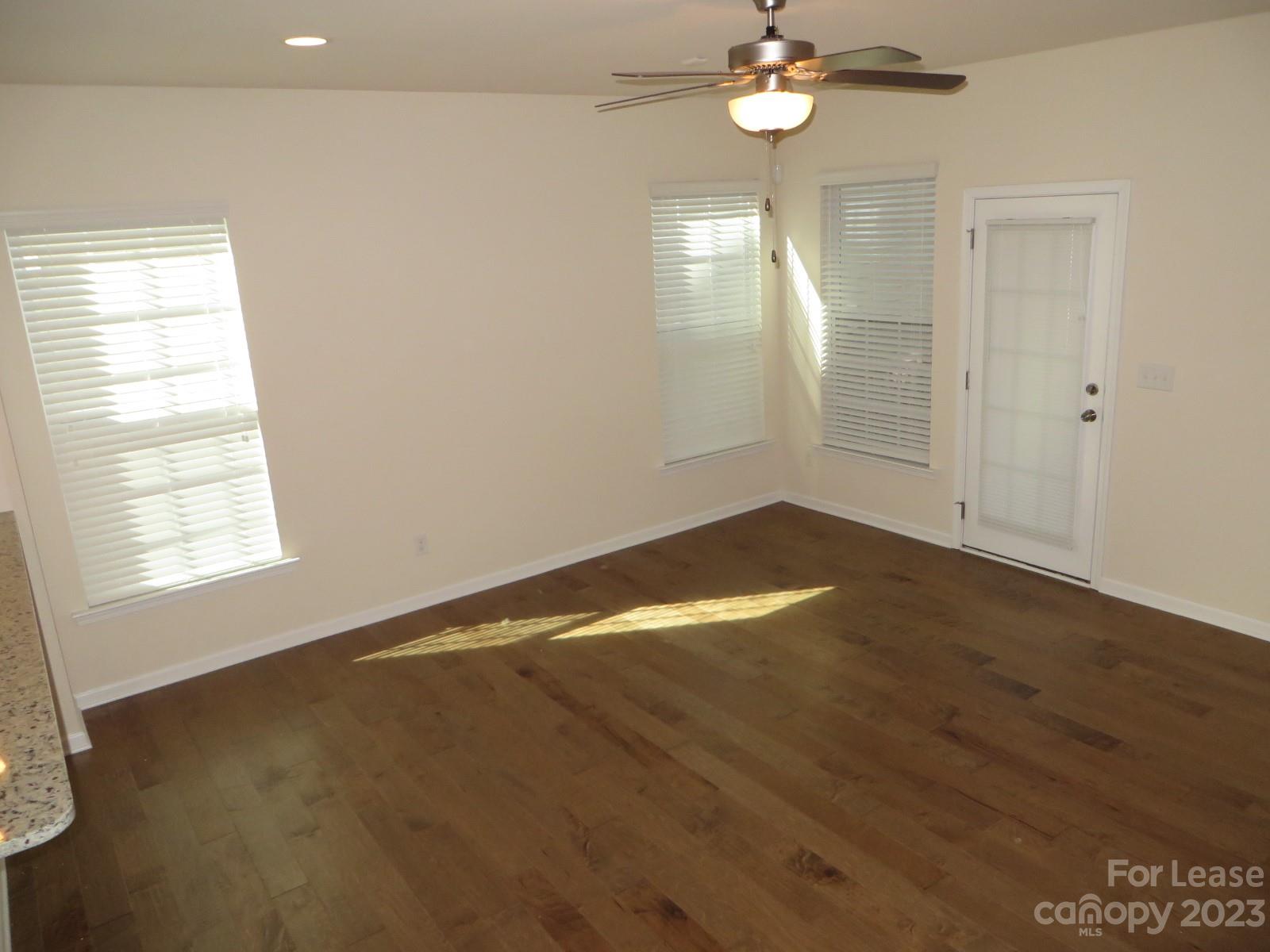 5107 Waterloo Drive Tega Cay, SC 29708 - Photo 4 of 25 an empty room with wooden floor fan and windows