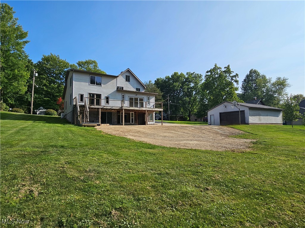 1325 Ohltown McDonald Road Mineral Ridge, OH 44440 - Photo 10 of 33 Back of house featuring a wooden deck, a garage, patio, extra parking and a yard