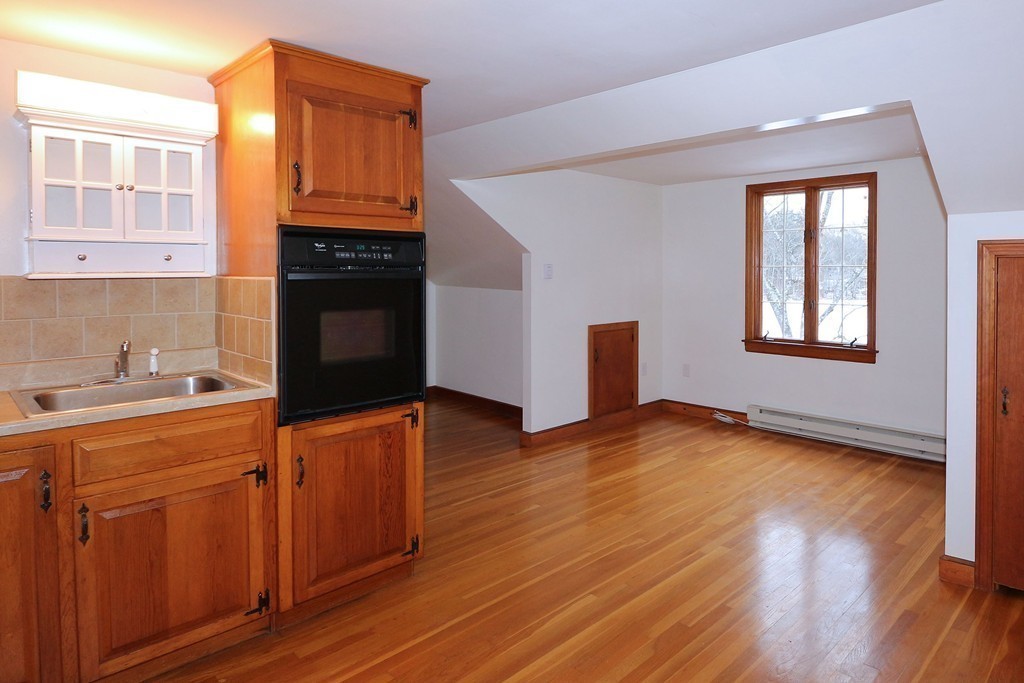 557 Dutton Road, Unit 3 Sudbury, MA 01776 - Photo 3 of 13 a kitchen with wooden floors and a stove