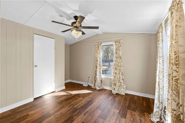 a view of a room with wooden floor and ceiling fan
