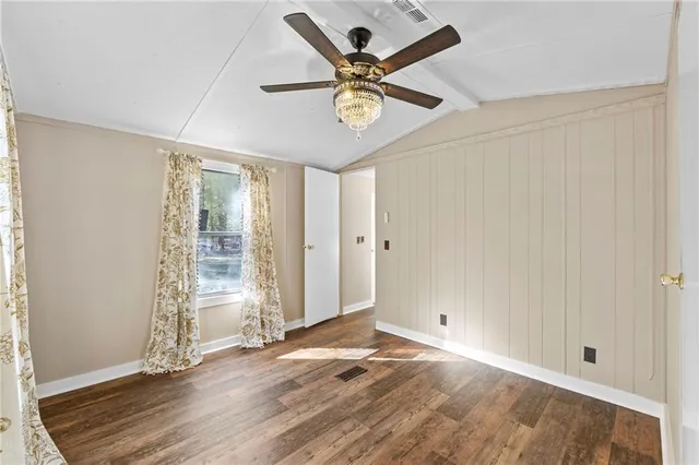 a view of a house with a small yard and wooden fence