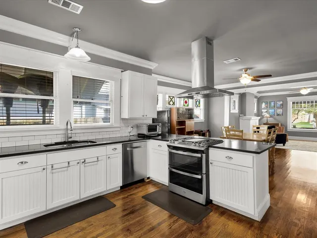 a kitchen with granite countertop white cabinets and white appliances