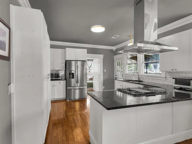 a kitchen with stainless steel appliances granite countertop a sink stove and refrigerator