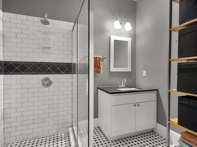 a bathroom with a sink a toilet a mirror and shower