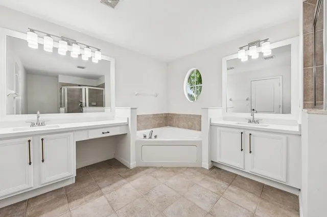 a bathroom with a sink vanity tub and a mirror