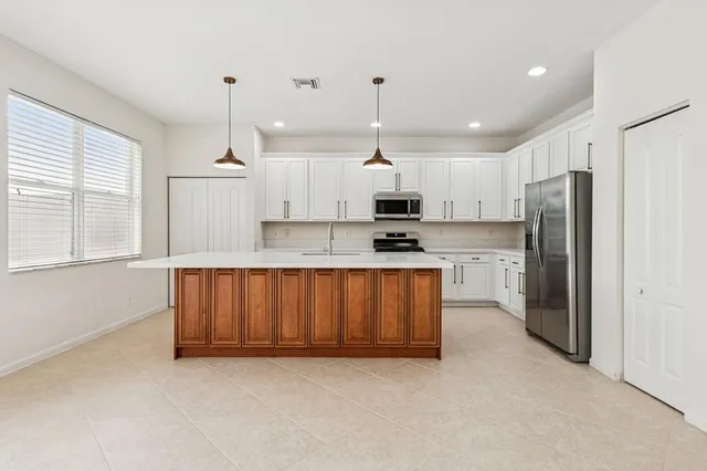 a kitchen with stainless steel appliances granite countertop a refrigerator sink and cabinets