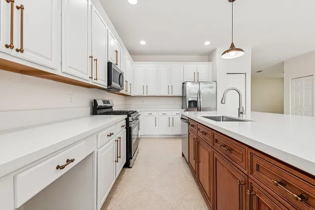 a kitchen with granite countertop white cabinets and stainless steel appliances