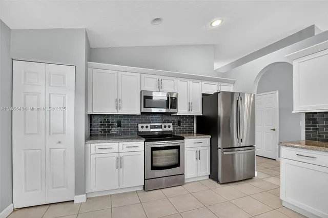 a kitchen with a sink a window and cabinets