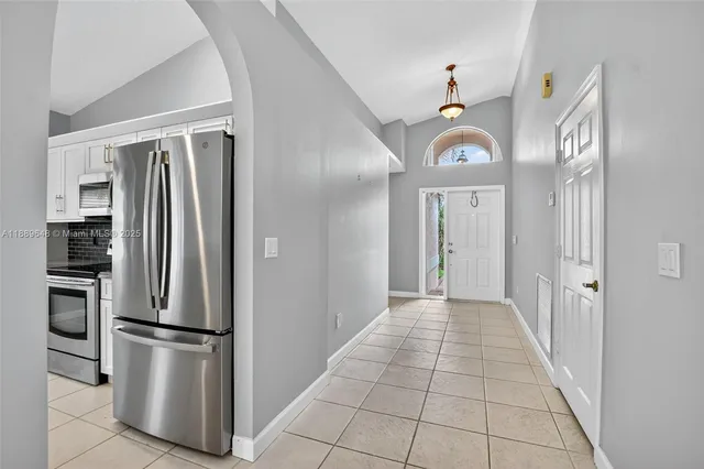 a view of an empty room with a chandelier fan