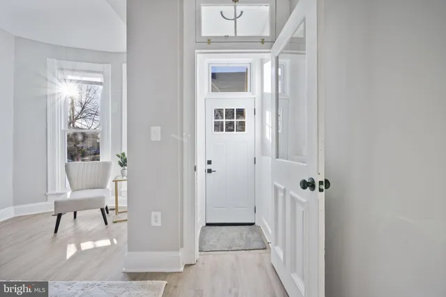 a view of a hallway with wooden floor and a livingroom