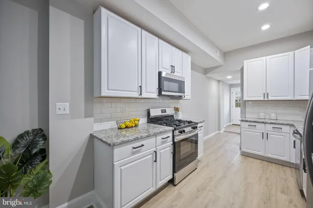 a kitchen with stainless steel appliances granite countertop a stove a sink dishwasher and a refrigerator