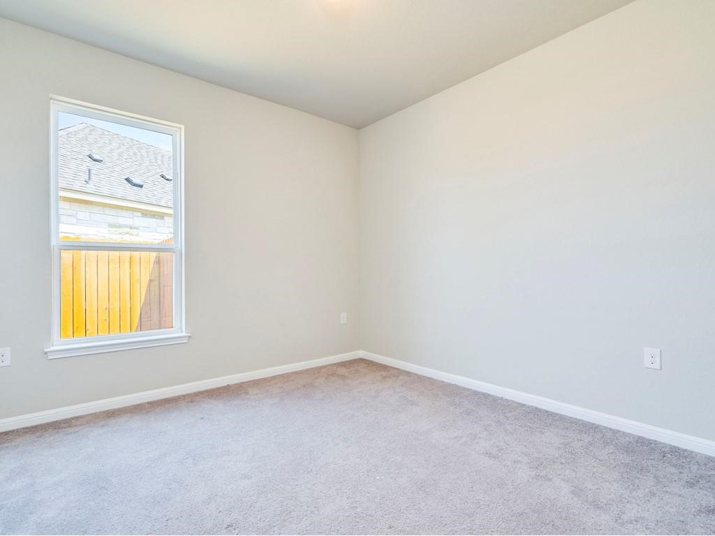 4210 Birdwatch Loop, Unit 2 Pflugerville, TX 78660 - Photo 18 of 31 A well-lit bedroom with soft carpeting and a window overlooking the neighborhood.