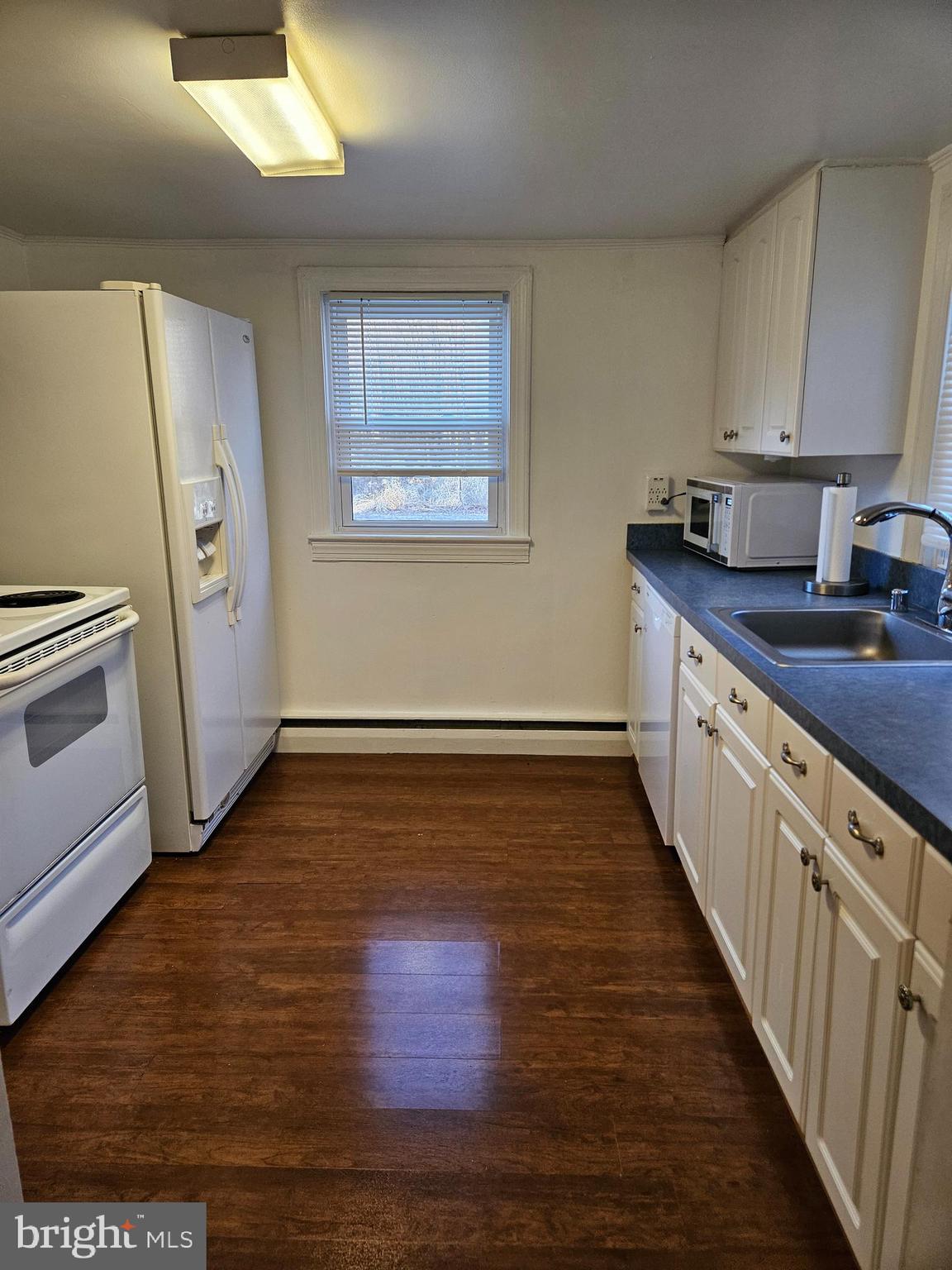 7204 Webster Lane Fort Washington, MD 20744 - Photo 3 of 27 a kitchen with wooden floors and cabinets