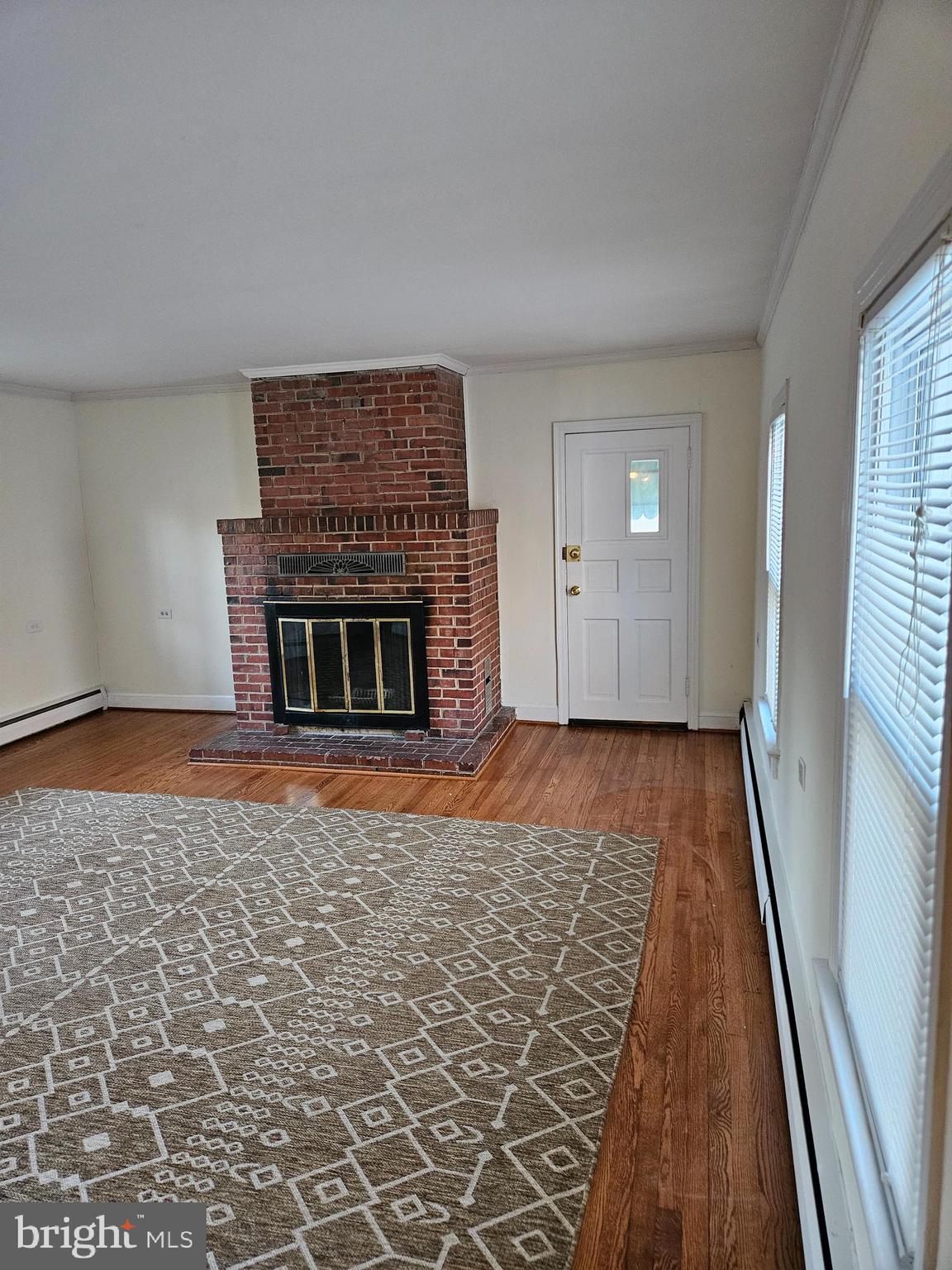 7204 Webster Lane Fort Washington, MD 20744 - Photo 6 of 27 an empty room with wooden floor fireplace and windows