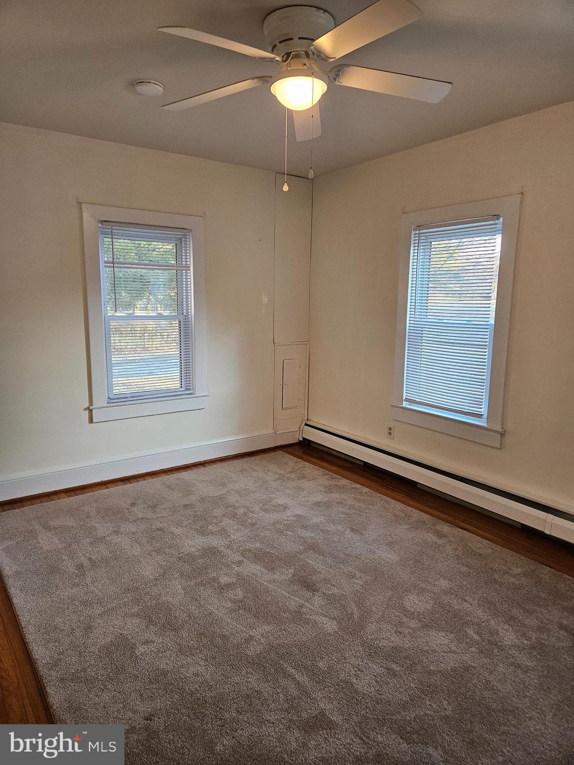 7204 Webster Lane Fort Washington, MD 20744 - Photo 10 of 27 an empty room with a chandelier fan and windows