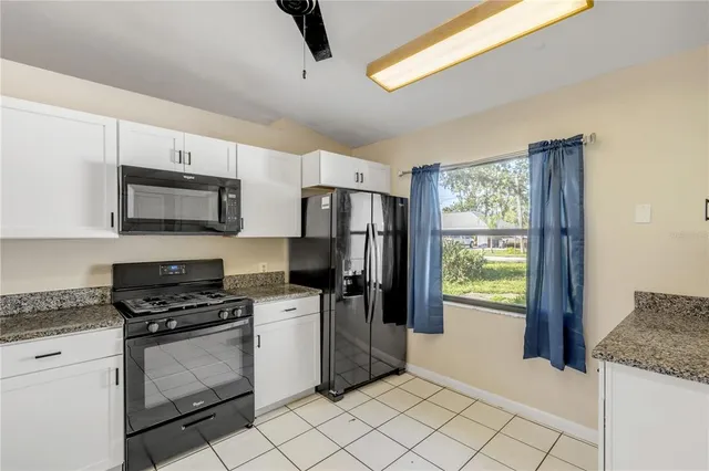 a kitchen with granite countertop a cabinets and steel appliances