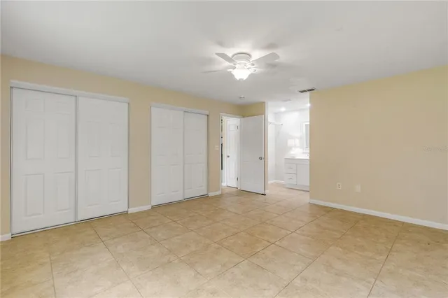 a view of an empty room and chandelier fan