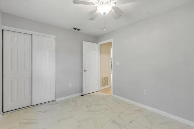 an empty room with a chandelier fan