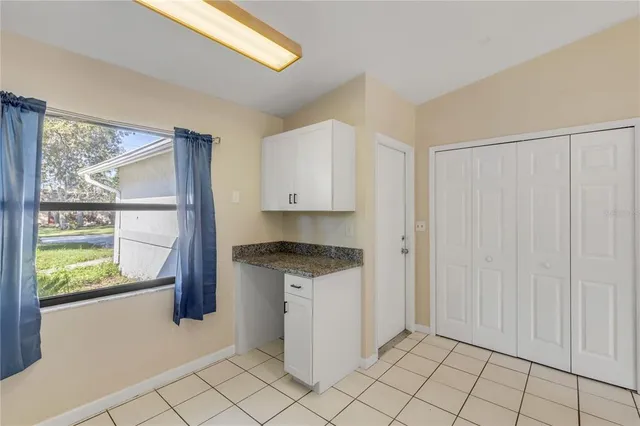 a kitchen with granite countertop white cabinets and window