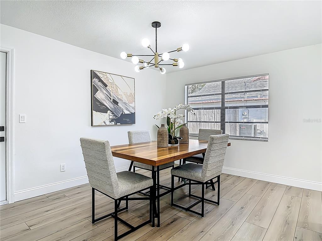 612 Devon Street Port Orange, FL 32127 - Photo 11 of 34 a dining room with furniture a chandelier and wooden floor
