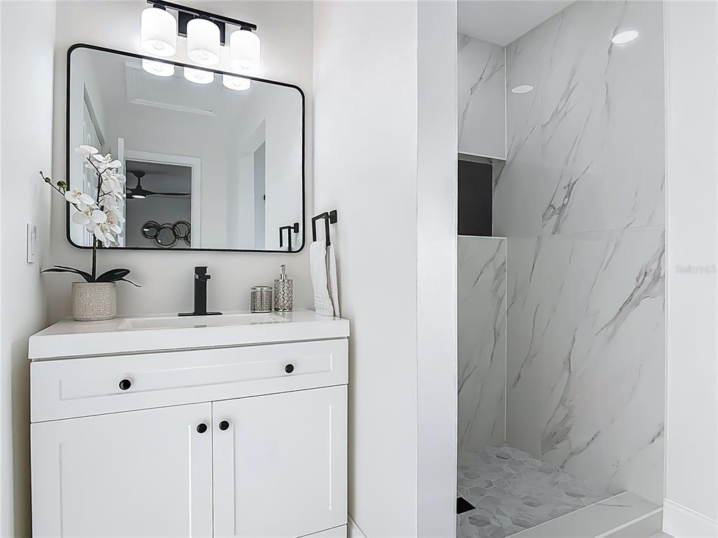 612 Devon Street Port Orange, FL 32127 - Photo 19 of 34 a bathroom with a sink a mirror and shower