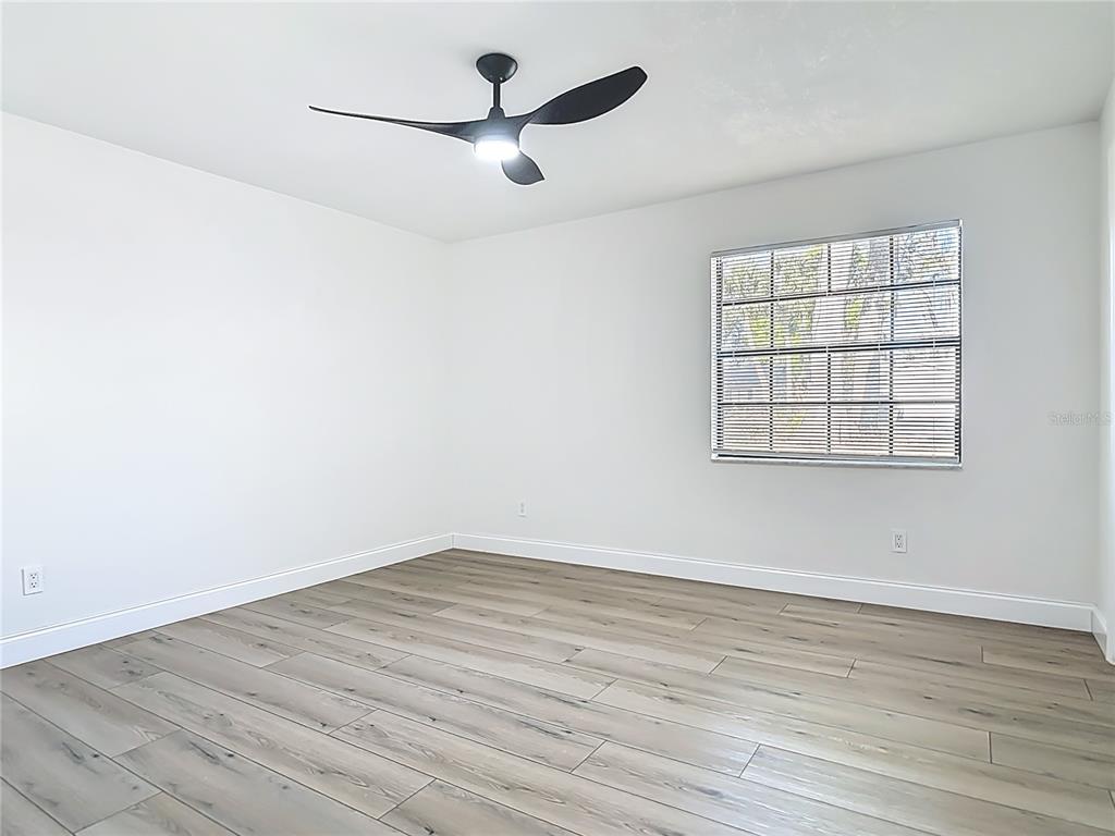 612 Devon Street Port Orange, FL 32127 - Photo 20 of 34 an empty room with wooden floor and windows