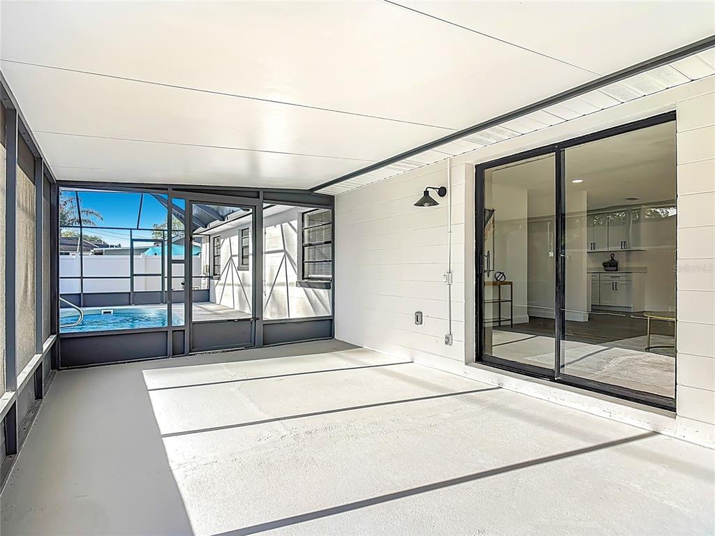 612 Devon Street Port Orange, FL 32127 - Photo 26 of 34 a spacious bedroom with a balcony a bed and glass door