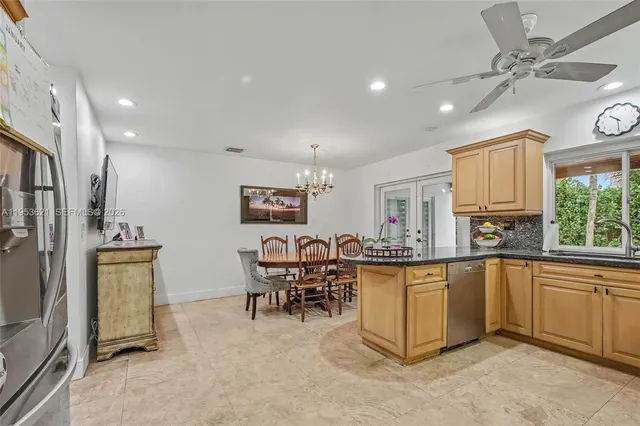 a kitchen with stainless steel appliances granite countertop a table and chairs in it