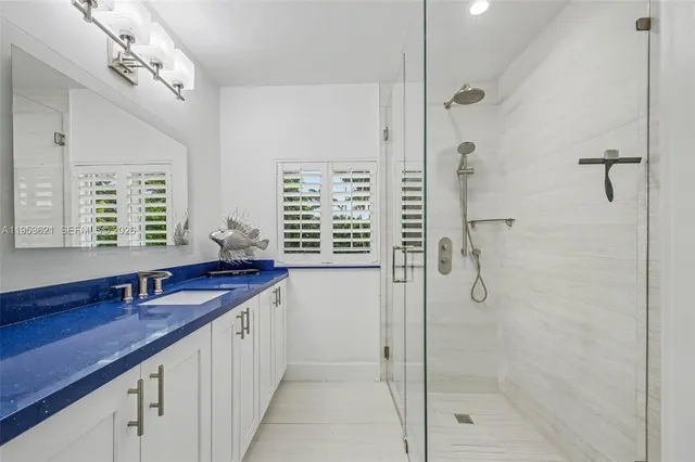 a bathroom with a granite countertop sink a shower and a mirror