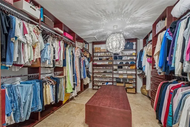 a view of walk in closet with clothes and shoes