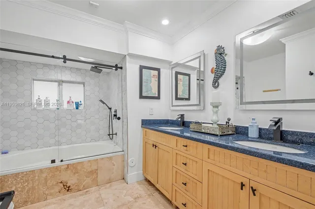 a bathroom with a granite countertop sink mirror bathtub and shower