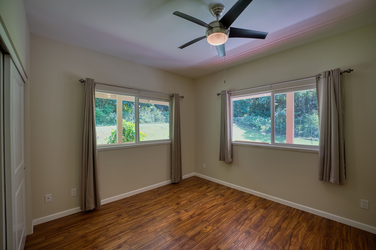 127 Opio Road Hilo, HI 96720 - Photo 11 of 21 an empty room with wooden floor fan and windows