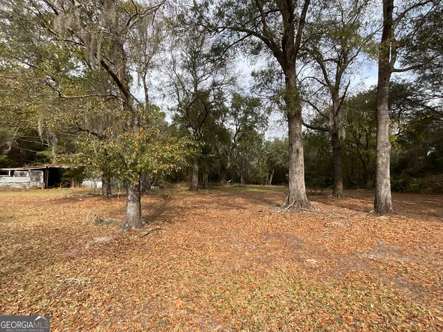 a backyard of a house with trees and outdoor seating