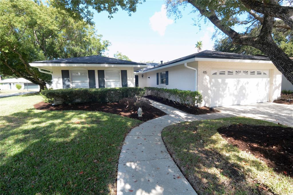 a front view of a house with a yard and potted plants