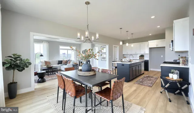 a view of a dining room and livingroom with furniture wooden floor and a chandelier