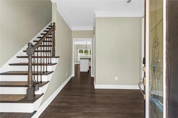 a view of a hallway with wooden floor and entryway