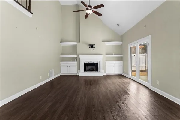 wooden floor fireplace and windows in an empty room