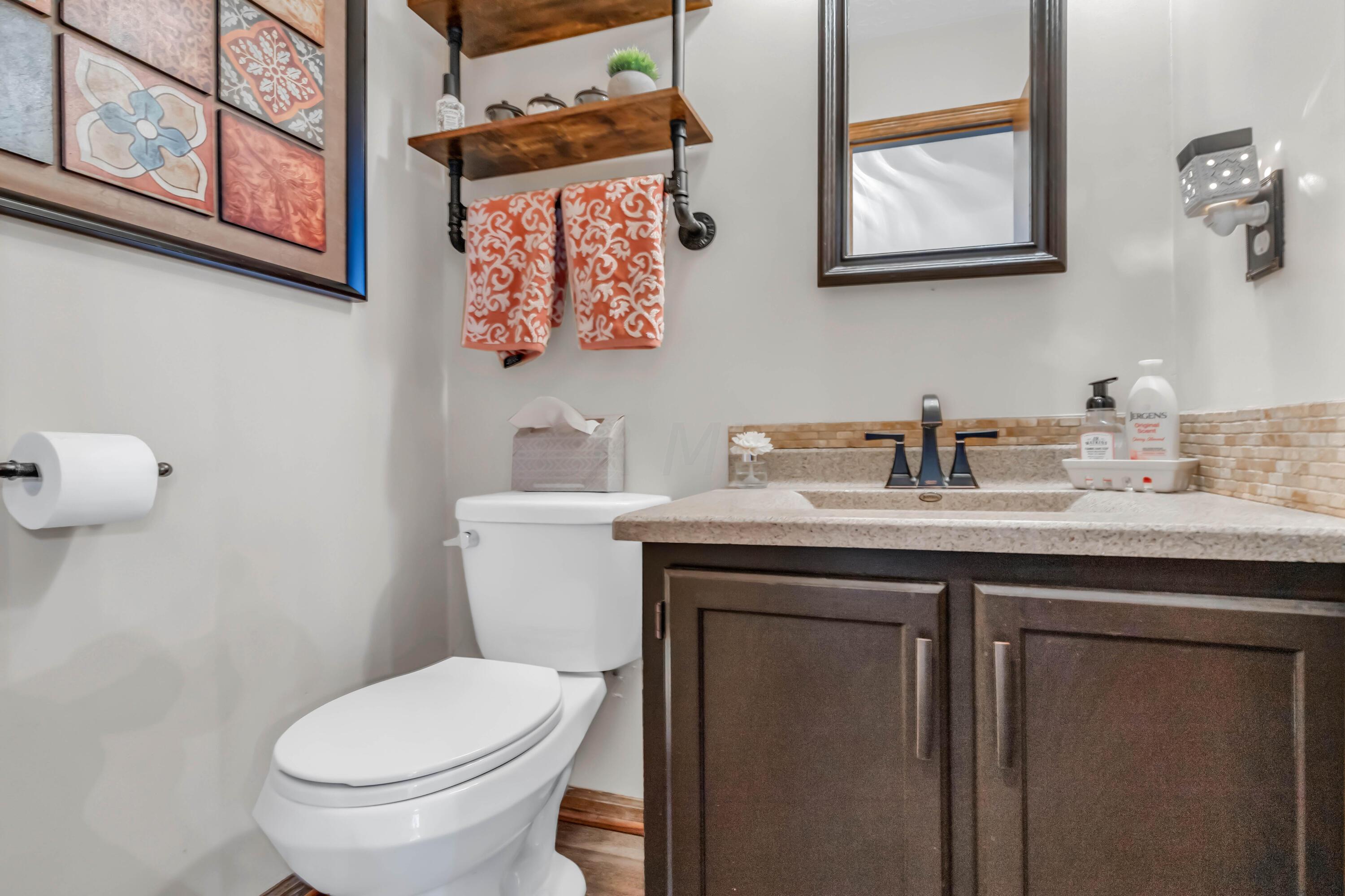 435 Emory Street Gahanna, OH 43230 - Photo 8 of 54 • New luxury vinyl plank
flooring
• Tan painted walls
• Enclosed vanity with single
bowl, cultured marble
sinktop
• 3 bulb wall light
• New faucet ~ 2022
• Ceiling exhaust
• Mirrored medicine cabinet
• Wall shelf remains