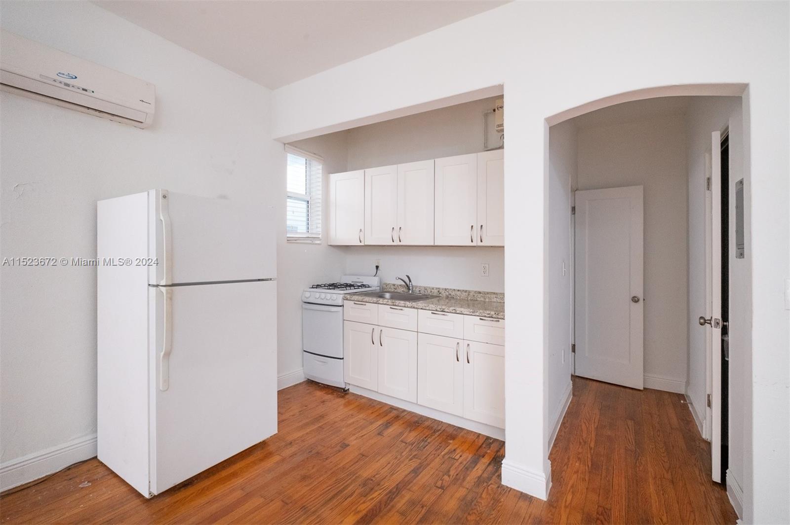 7936 Harding Avenue Miami Beach, FL 33141 - Photo 11 of 18 a kitchen with stainless steel appliances granite countertop a refrigerator sink and cabinets