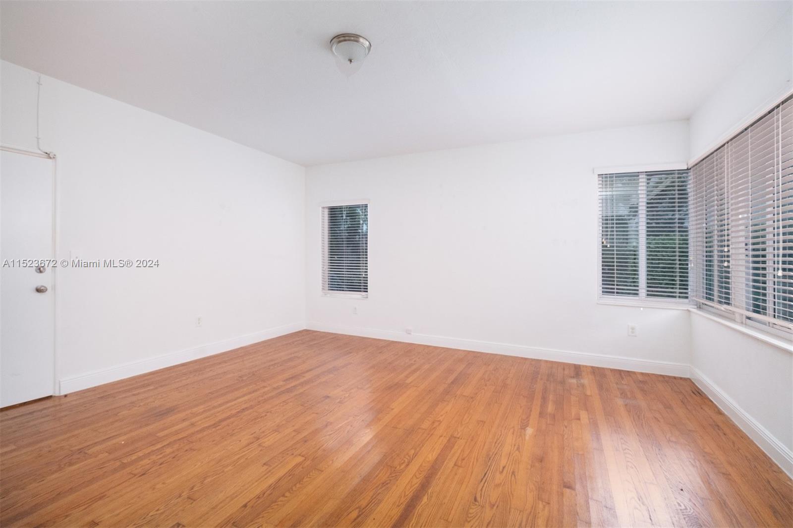 7936 Harding Avenue Miami Beach, FL 33141 - Photo 7 of 18 a view of empty room with wooden floor and fan