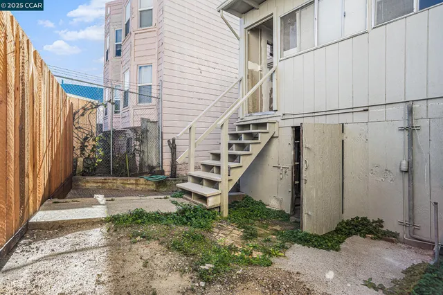 a view of a white house with a small yard and wooden floor