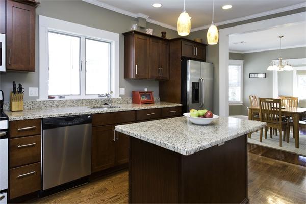 a kitchen with kitchen island granite countertop a sink a counter top space appliances and cabinets