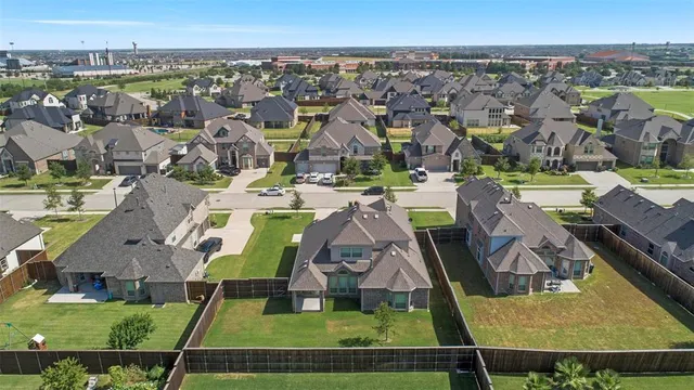 an aerial view of residential houses with outdoor space and swimming pool