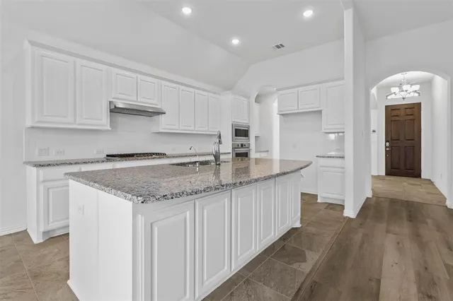 a kitchen with stainless steel appliances granite countertop a sink and cabinets